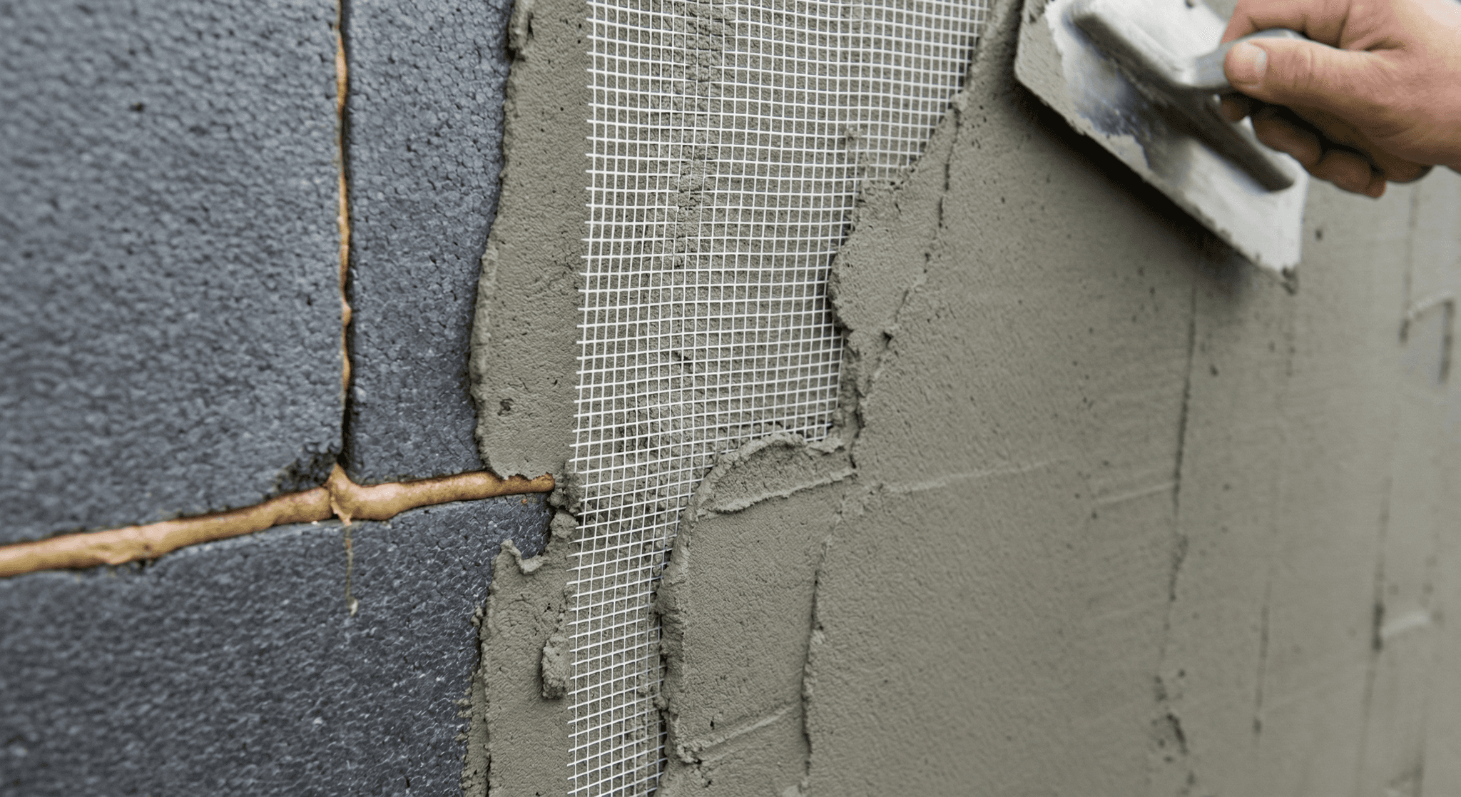 Glasvezelnet wordt ingebed in wapeningsmortel over isolatieplaten - ETICS installatieproces